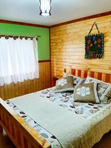 une chambre avec un grand lit avec des oreillers dessus dans l'établissement Apart "Villa Antonia" Cabañas y Departamentos Delegaciones, à Dalcahue 13 autres photos