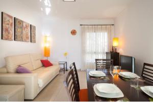 ein Wohnzimmer mit einem Sofa und einem Esstisch in der Unterkunft La Manga beachfront seaview apartment in San Blas