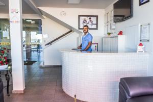 a man standing behind a bar in a restaurant at Pousada Paraiso in Guanambi