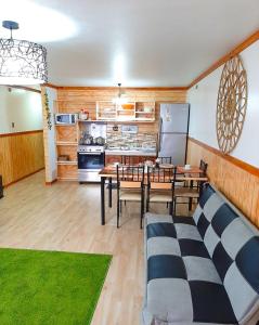 une cuisine et une salle à manger avec une table et un réfrigérateur dans l'établissement Apart "Villa Antonia" Cabañas y Departamentos Delegaciones, à Dalcahue