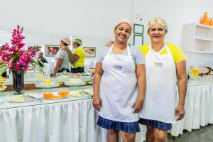 two chefs standing in front of a table of food at Pousada Paraiso in Guanambi