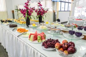 a long table with many plates of fruit on it at Pousada Paraiso in Guanambi