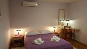 a bedroom with a bed with two white towels on it at Apartments Lukoran in Lukoran