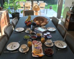 a blue table topped with plates and bowls of food at Grysperre B&B in Hooglede