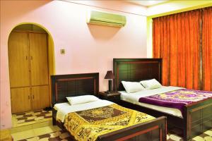 um quarto de hotel com duas camas num quarto em River Palace Hotel em Suat