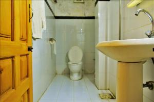 uma casa de banho com um WC branco e um lavatório. em River Palace Hotel em Suat