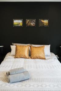 a bedroom with a white bed with three pictures on the wall at de Kleijne Kaap in Potchefstroom