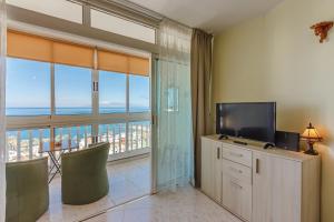un soggiorno con TV e una grande finestra di Las Americas Best! Torres de Yomely11 a Playa de las Americas