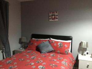 Un dormitorio con una cama roja con sábanas rojas. en Garron View en Cushendall