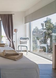 1 dormitorio con cama y ventana grande en Lidea Boutique Hotel, en Potamós