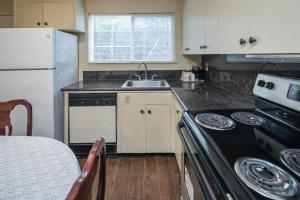 a kitchen with a stove top oven and a sink at Hotel Rose Garden in San Jose