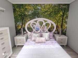 a bedroom with a white bed with trees in the background at Apartamento Felipe V in Ronda