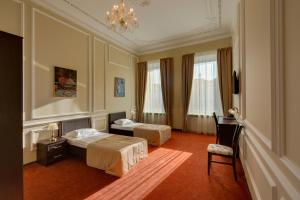 a hotel room with two beds and a desk at Solo na Liteynom prospekte in Saint Petersburg