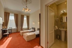 a hotel room with two beds and a bathroom at Solo na Liteynom prospekte in Saint Petersburg