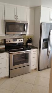a kitchen with a stove and a stainless steel refrigerator at Beachfront 2 Bed 2 Bath Penthouse Condo in Marco Island