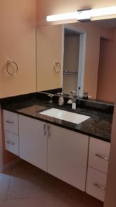 a bathroom with a sink and a large mirror at Beachfront 2 Bed 2 Bath Penthouse Condo in Marco Island