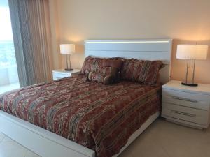 a bedroom with a bed with two night stands and two lamps at Beachfront 2 Bed 2 Bath Penthouse Condo in Marco Island