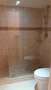 a bathroom with a shower and a toilet at Beachfront 2 Bed 2 Bath Penthouse Condo in Marco Island
