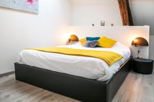 a bedroom with a large bed with yellow and white sheets at Chablis SPA : duplex Grand Cru in Chablis