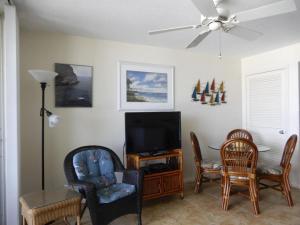 a living room with a flat screen tv and chairs at Gorgeous views that stretch forever right from your very own private balcony! in Marco Island