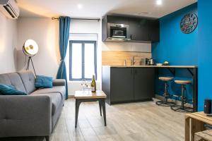 a living room with a couch and a kitchen at Chablis SPA : duplex Grand Cru in Chablis