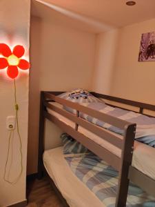 ダウンにあるFerienhaus am Sauerbrunnenのベッドルーム1室(赤い花の壁に二段ベッド1組付)