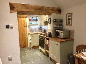 a small kitchen with white cabinets and a microwave at The Outhouse - Ground Floor Studio in Melbourne