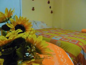 un jarrón de flores sentado en una mesa con una cama en BiosWild, en Cusco