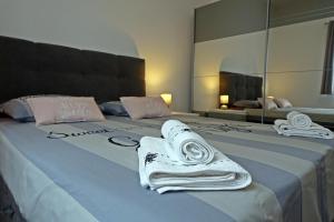 - un lit avec des serviettes et un miroir dans l'établissement Apartment Denis, à Opatija