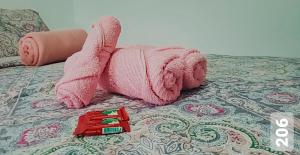 a pink elephant toy is laying on a bed at Cantinho Suico Aluguel de Temporada in Nova Friburgo