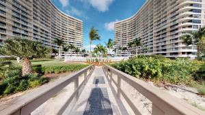 a bridge in front of two tall buildings at South Seas Tower 3 #1009 - Stunning 2/2 Beachfront Condo w/Endless Beach View in Marco Island