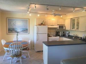 a kitchen with a table and a white refrigerator at Ideal for Conference @ J.W. Marriott / Access to Beach!! in Marco Island