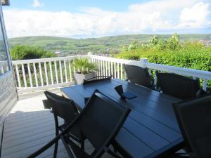 uma mesa azul e cadeiras num deque com vista em 225 Buttercup Swanage Bay View - Vacation Home em Swanage