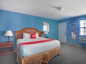 a bedroom with a large bed with blue walls at OYO Hotel Jacksboro TX - Fort Richardson in Jacksboro