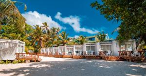 un complejo con mesas y sillas en la playa en Hotel Reina del Mar By Dorado, en San Andrés