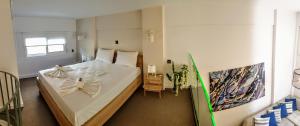 a bedroom with a large white bed with a bow on it at City House Loft in Kalamata