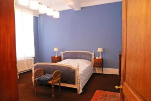 1 dormitorio con cama y pared azul en Villa Theresa à 25 min de PAIRI DAIZA en Soignies