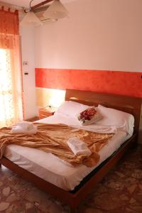 Bett in einem Schlafzimmer mit einer roten und weißen Wand in der Unterkunft Maremma Holidays - Cimarosa Apartment in Follonica