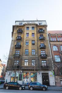 two cars parked in front of a tall building at Spicy Hostel in Budapest