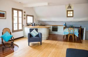 uma sala de estar com uma cozinha e uma mesa e cadeiras em La Villanelle - Magnifique vue sur le lac, 5 minutes à pied de la plage em Veyrier-du-Lac