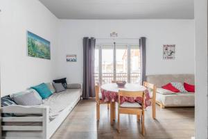 a living room with a table and a couch at Twins 2 Alpes centre station in Mont-de-Lans