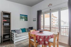 a living room with a table and a couch at Twins 2 Alpes centre station in Mont-de-Lans