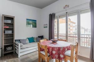a living room with a table and a couch at Twins 2 Alpes centre station in Mont-de-Lans +9 photos