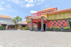 ein Gebäude mit einem Schild an der Seite in der Unterkunft SUPER OYO Flagship 2688 Guntur Hotel in Denpasar