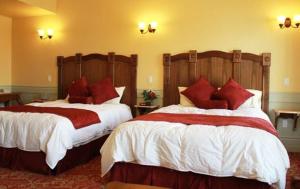 a hotel room with two beds with red pillows at Windsor Hotel & Restaurant in Del Norte