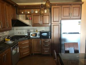 a kitchen with wooden cabinets and a refrigerator at Lazorde bay duplex chalet, North coast in El Alamein