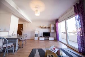 a kitchen and living room with a large window at Apartman 2 Relax Zadar in Zadar