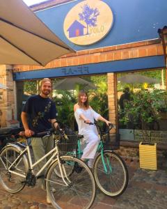 een man en vrouw die met hun fietsen voor een winkel staan bij Yolo Hostel Medellin in Medellín