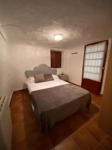 1 dormitorio con 1 cama grande en una habitación en La Cueva deLola, en Alcalá del Júcar