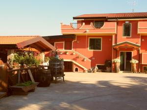 - un grand bâtiment rouge avec une terrasse en face dans l'établissement Le Palme Bed And Breakfast, à Briatico